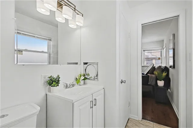 a en suite bathroom with a granite countertop sink and a mirror
