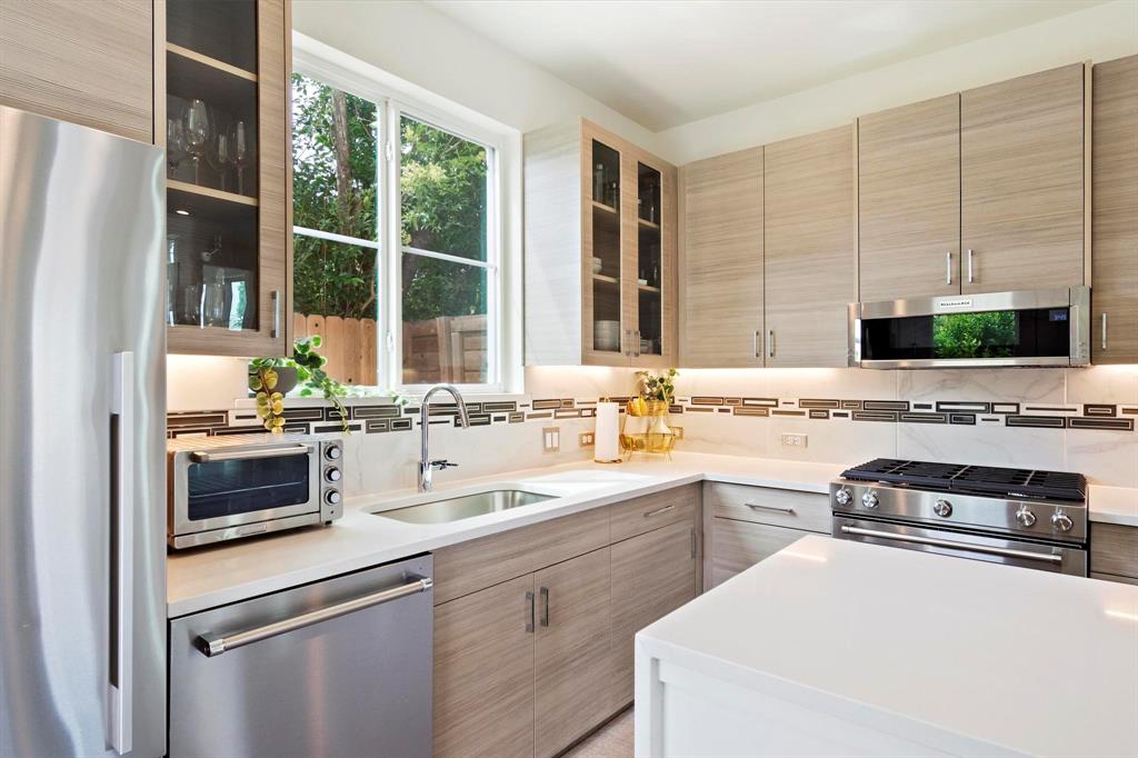 911 Stobaugh Street, Unit 2 Austin, TX 78757 - Photo 5 of 27 Contemporary kitchen featuring light wood-finish cabinetry, stainless steel appliances, and a white countertop