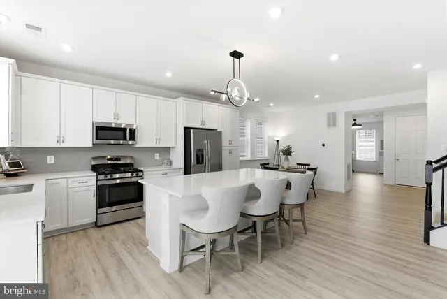 a kitchen with stainless steel appliances a stove a sink and a refrigerator