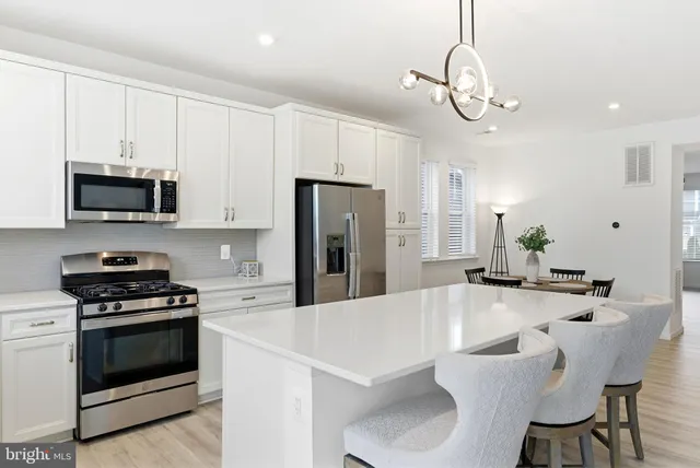 a living room with furniture a dining table and a potted plant