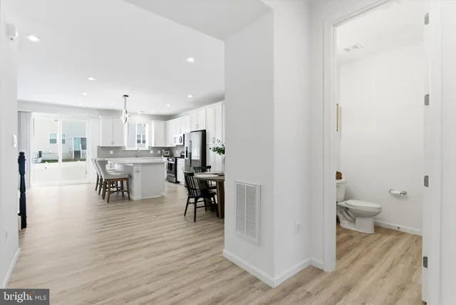 a living room with furniture and a dining table with kitchen view