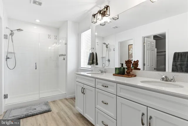 a bathroom with a granite countertop shower a toilet and a sink