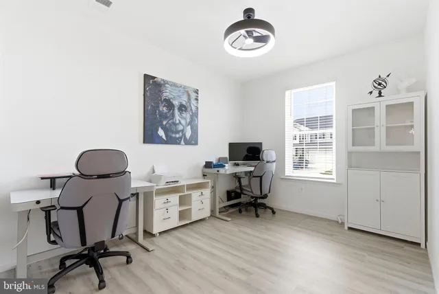 a view of a workspace with furniture and a window