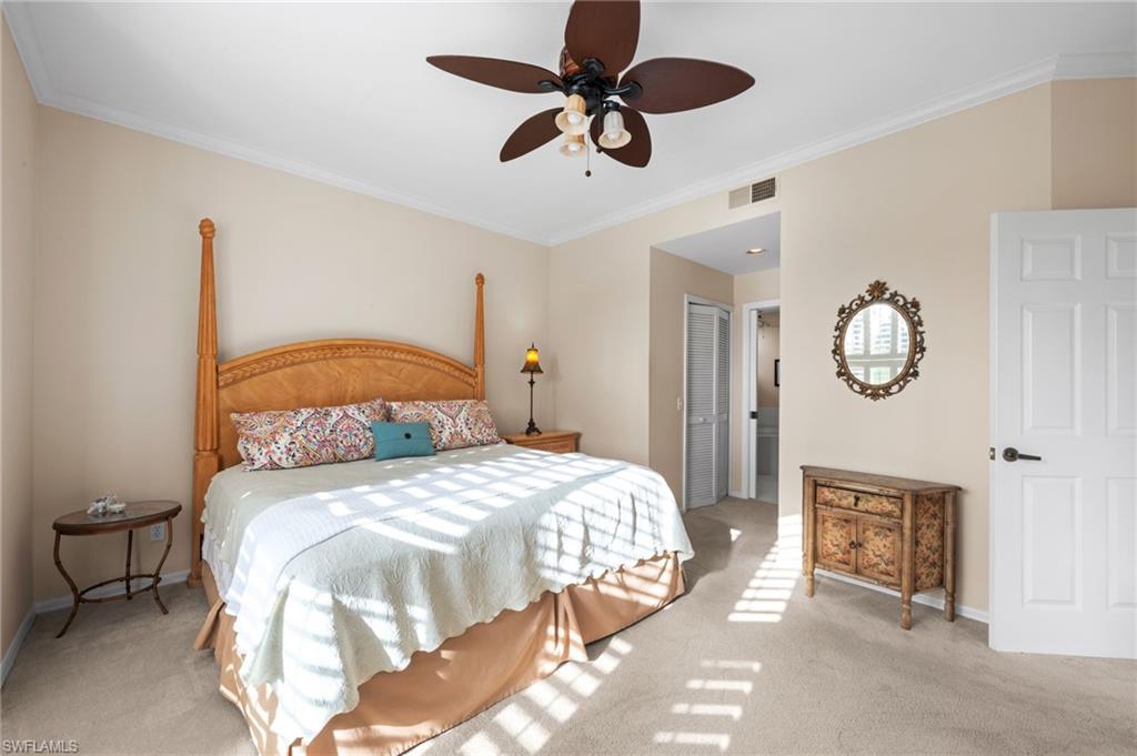 8015 Tiger Cove, Unit 204 Naples, FL 34113 - Photo 16 of 24 a bedroom with a bed and a chandelier