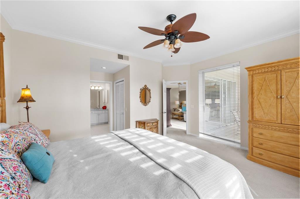 8015 Tiger Cove, Unit 204 Naples, FL 34113 - Photo 17 of 24 a bedroom with a large bed and a chandelier