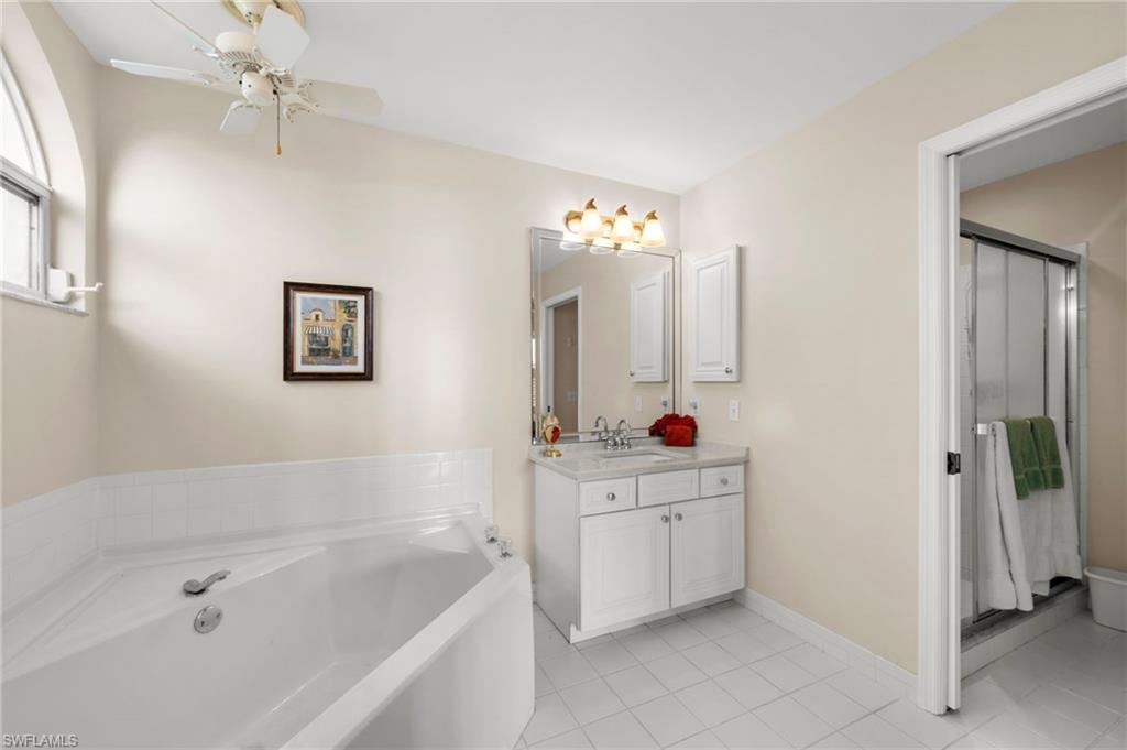 8015 Tiger Cove, Unit 204 Naples, FL 34113 - Photo 19 of 24 a bathroom with a bathtub a sink and a mirror