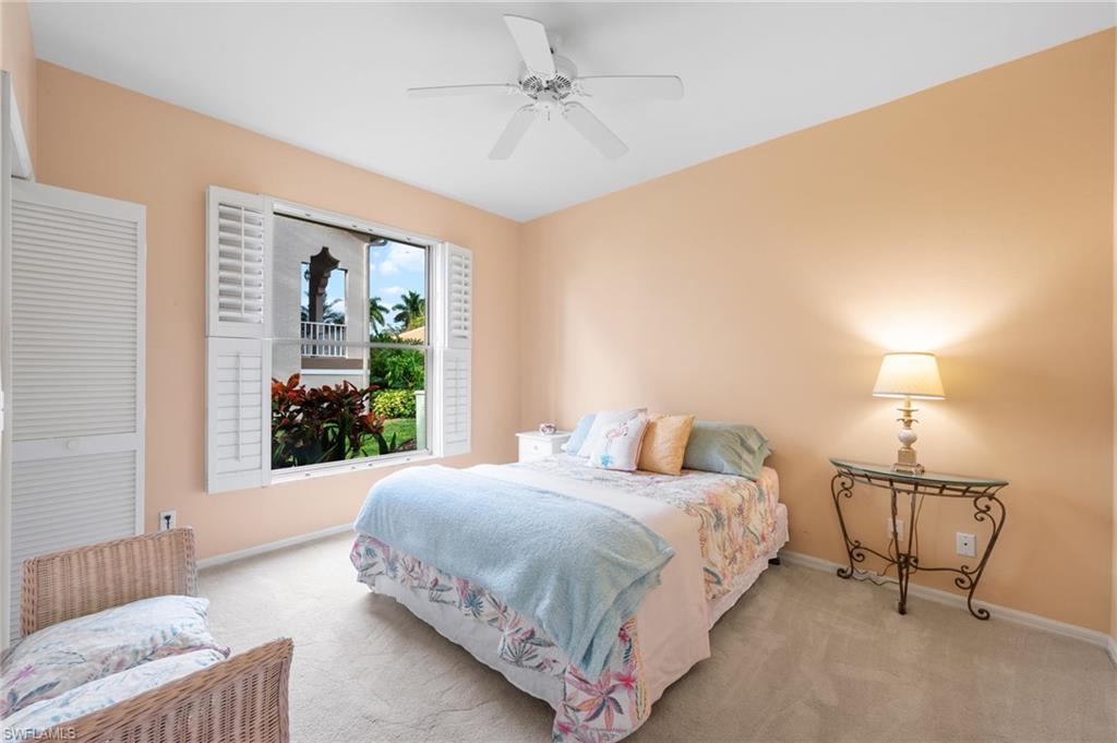 8015 Tiger Cove, Unit 204 Naples, FL 34113 - Photo 22 of 24 a bedroom with a bed a chandelier and window
