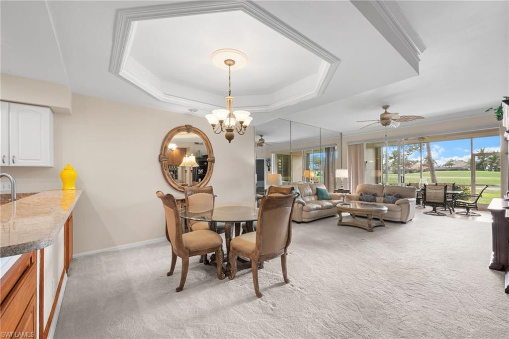 8015 Tiger Cove, Unit 204 Naples, FL 34113 - Photo 3 of 24 a living room with furniture a chandelier and a fireplace