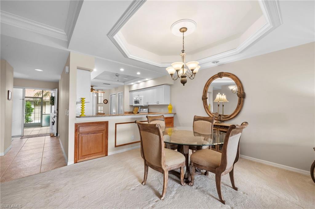 8015 Tiger Cove, Unit 204 Naples, FL 34113 - Photo 8 of 24 a view of a dining room with furniture a chandelier and wooden floor