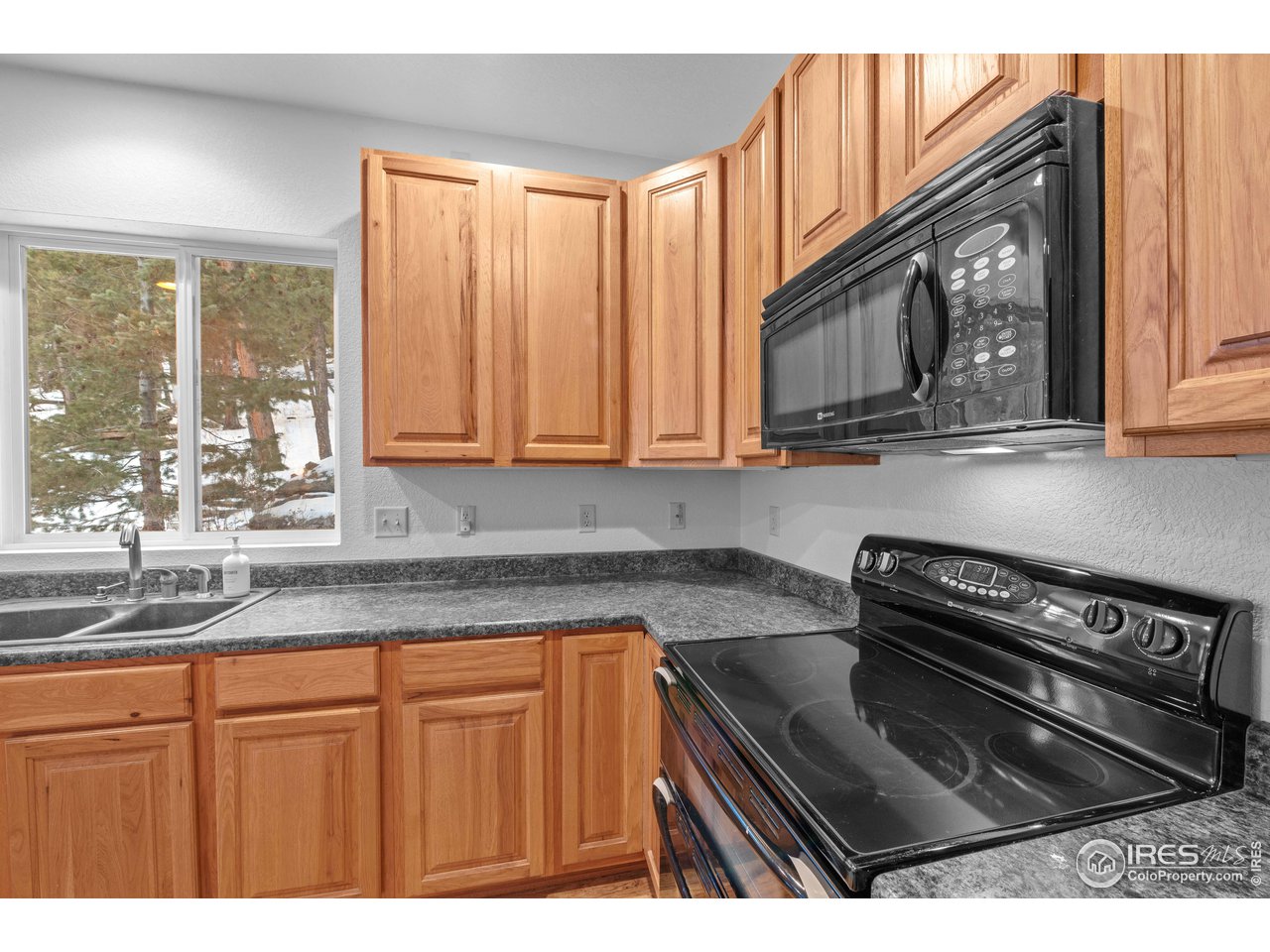 339 Cedar Drive Lyons, CO 80540 - Photo 18 of 37 a kitchen with stainless steel appliances granite countertop a stove a sink and a microwave