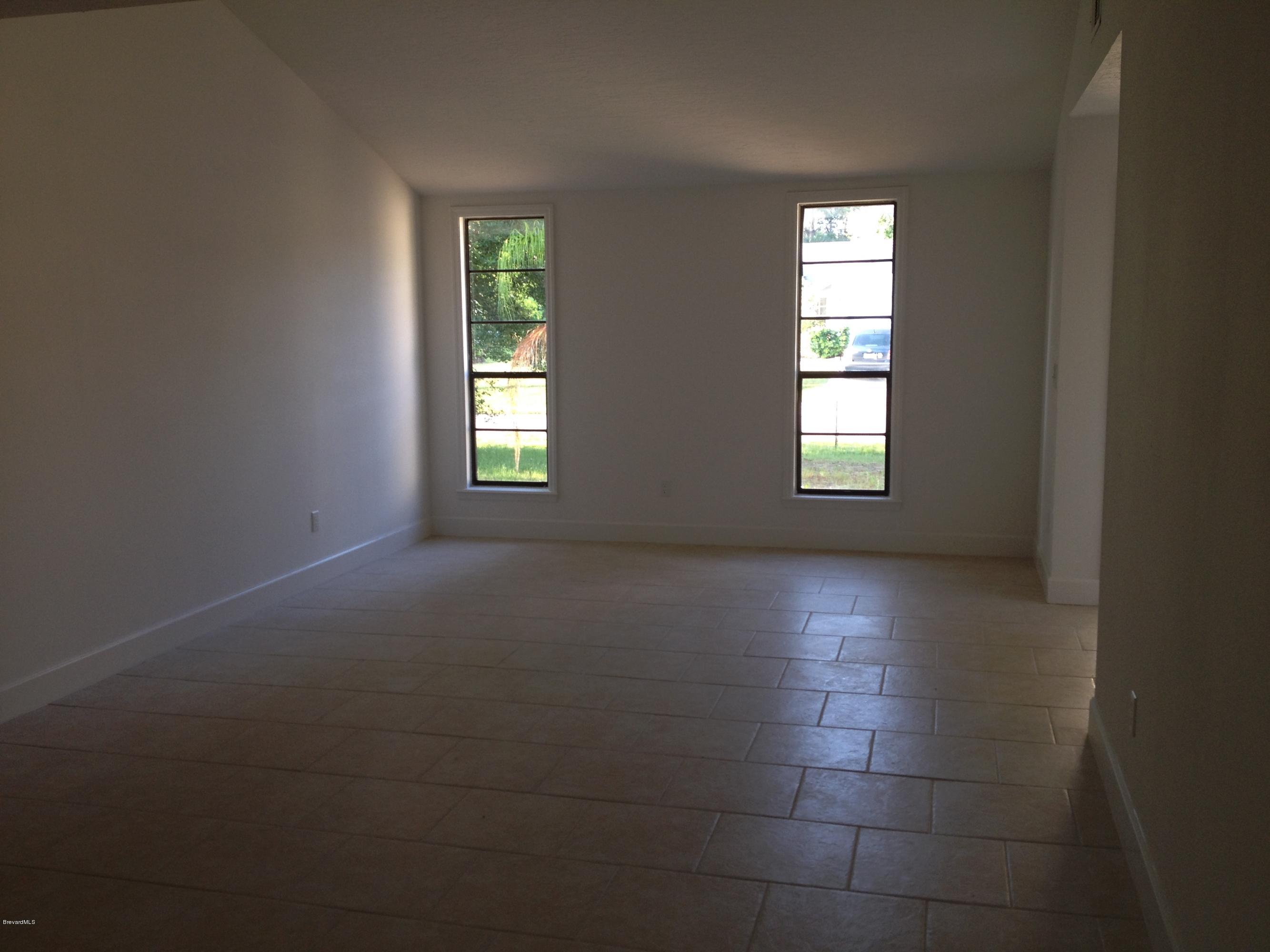 385 Rheine Road Northwest Palm Bay, FL 32907 - Photo 6 of 15 an empty room with windows and mirror