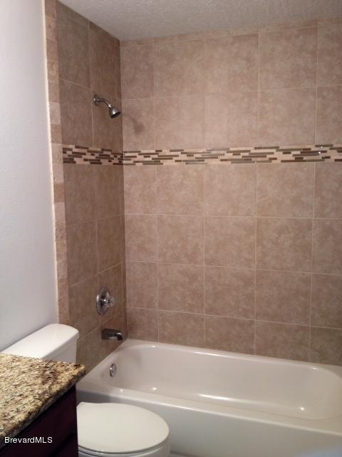 385 Rheine Road Northwest Palm Bay, FL 32907 - Photo 8 of 15 a bathroom with a granite countertop bathtub shower sink vanity and toilet
