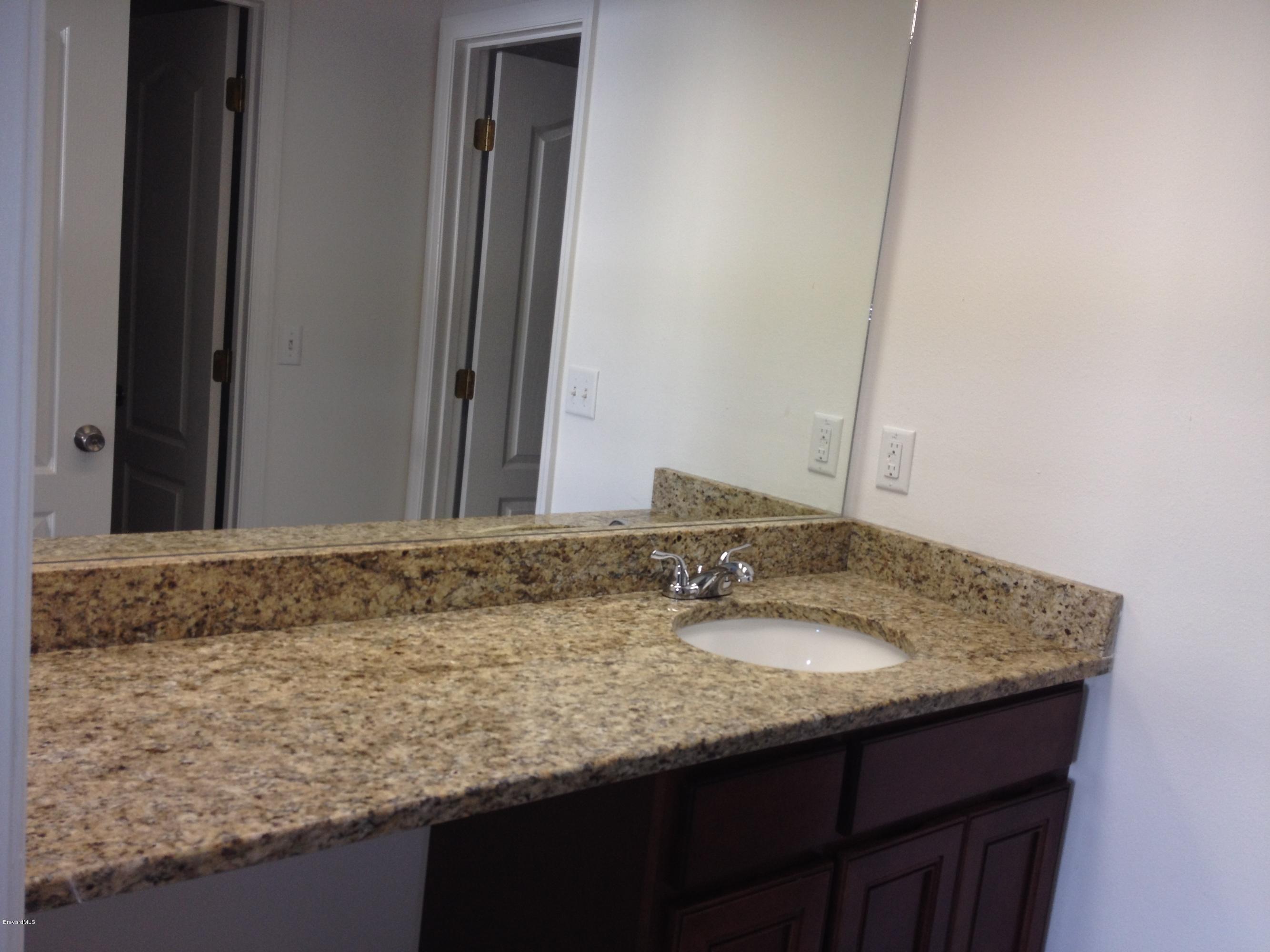 385 Rheine Road Northwest Palm Bay, FL 32907 - Photo 10 of 15 a bathroom with a granite countertop sink and a mirror