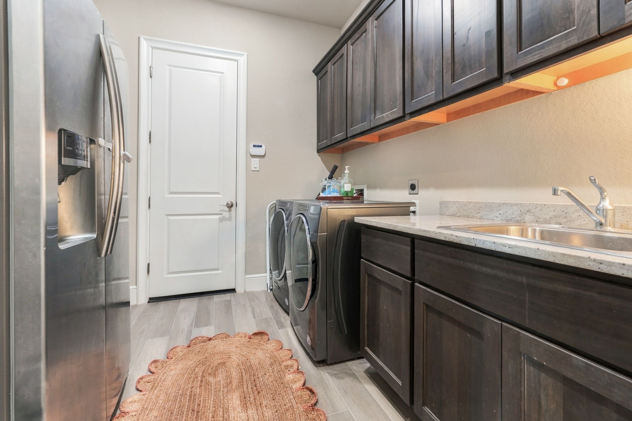 26910 Selinsgrove Road Magnolia, TX 77354 - Photo 37 of 47 A true utility room with extensive upper and lower cabinetry for storage. A convenient sink for all of your laundry needs. Generous counter space provides a practical spot for folding and organizing.