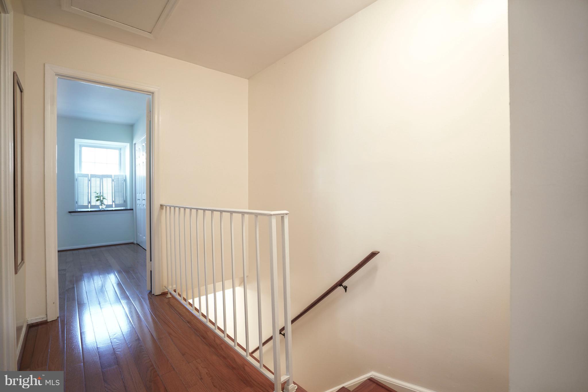 8836 Surveyors Place Springfield, VA 22152 - Photo 18 of 48 a view of a hallway with wooden floor and staircase