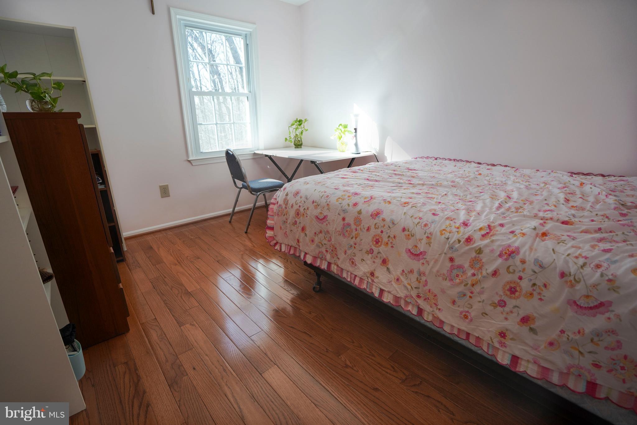 8836 Surveyors Place Springfield, VA 22152 - Photo 26 of 48 a bedroom with a bed window and wooden floor