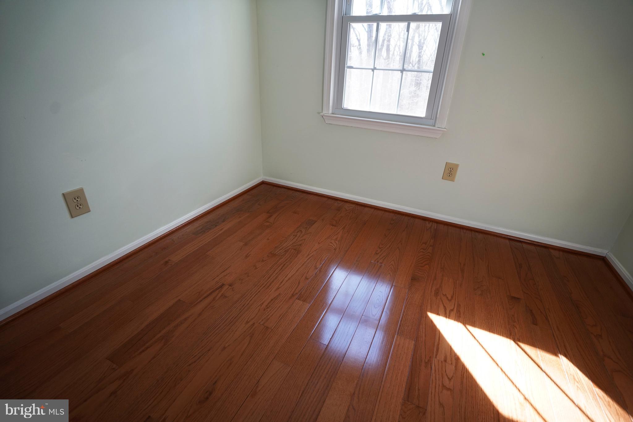 8836 Surveyors Place Springfield, VA 22152 - Photo 28 of 48 an empty room with wooden floor and windows