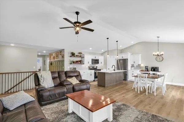 a kitchen with stainless steel appliances kitchen island a sink a stove and a wooden floors