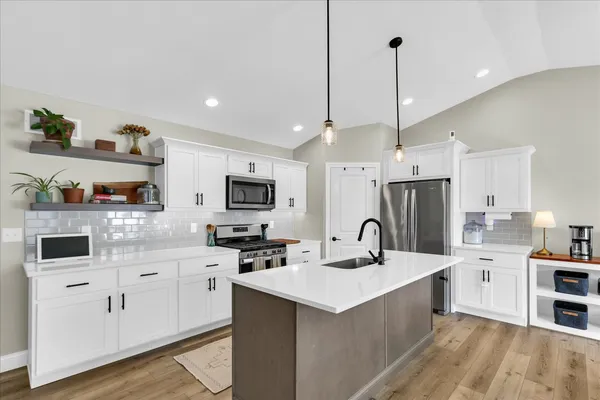 a kitchen with stainless steel appliances granite countertop a sink stove and refrigerator