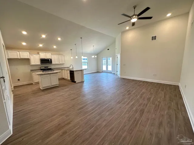 a view of kitchen with a sink a refrigerator and a stove top oven