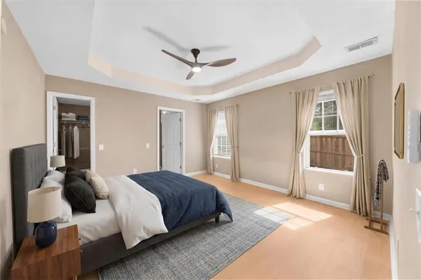 a spacious bedroom with a bed and wooden floor