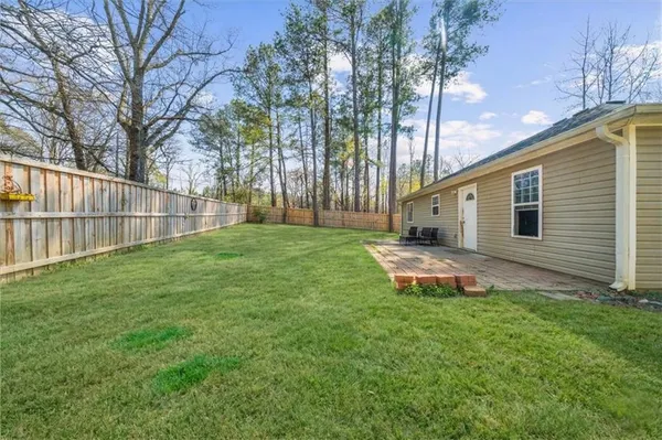 a backyard of a house with table and chairs
