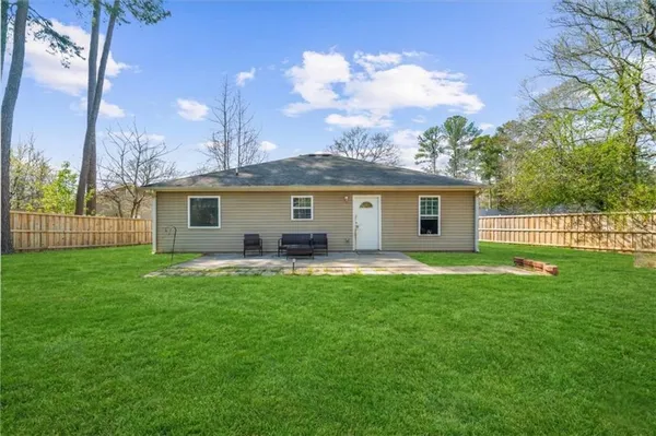 a backyard of a house with table and chairs