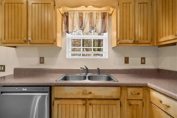 a kitchen with stainless steel appliances granite countertop white cabinets a sink and dishwasher