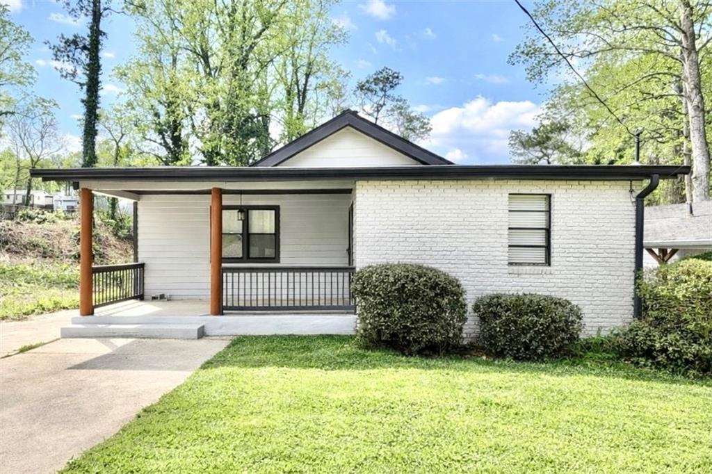 1291 Lorenzo Drive Southwest Atlanta, GA 30310 - Photo 1 of 20 a front view of a house with garden