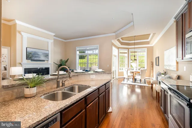 a kitchen with granite countertop a sink a counter top space and stainless steel appliances