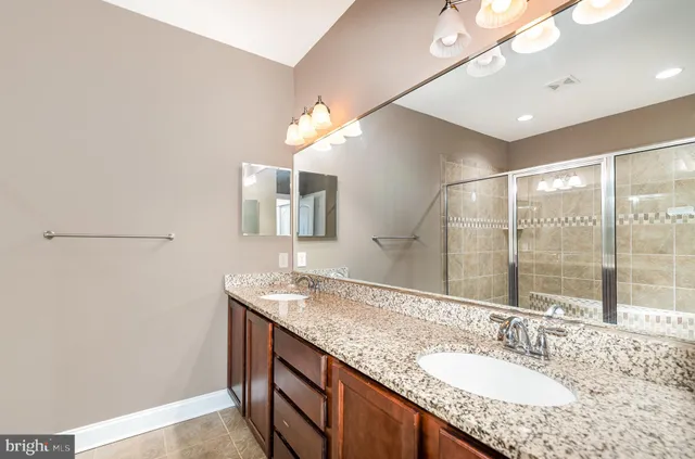 a bathroom with a granite countertop sink a large mirror and vanity