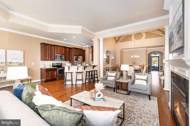 a living room with fireplace furniture and a view of kitchen