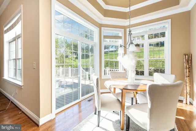 a view of a dining room with furniture large windows and wooden floor