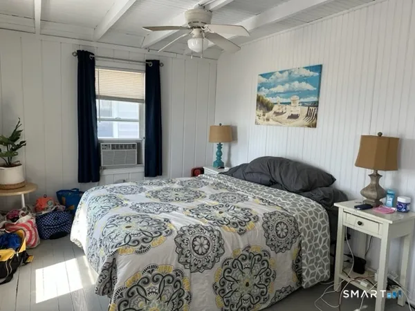 a bedroom with a bed painting on wall and a window