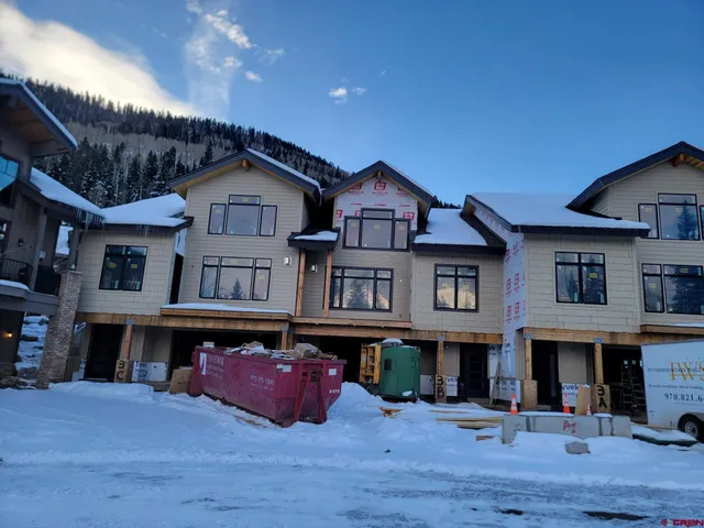 a front view of a building with cars parked