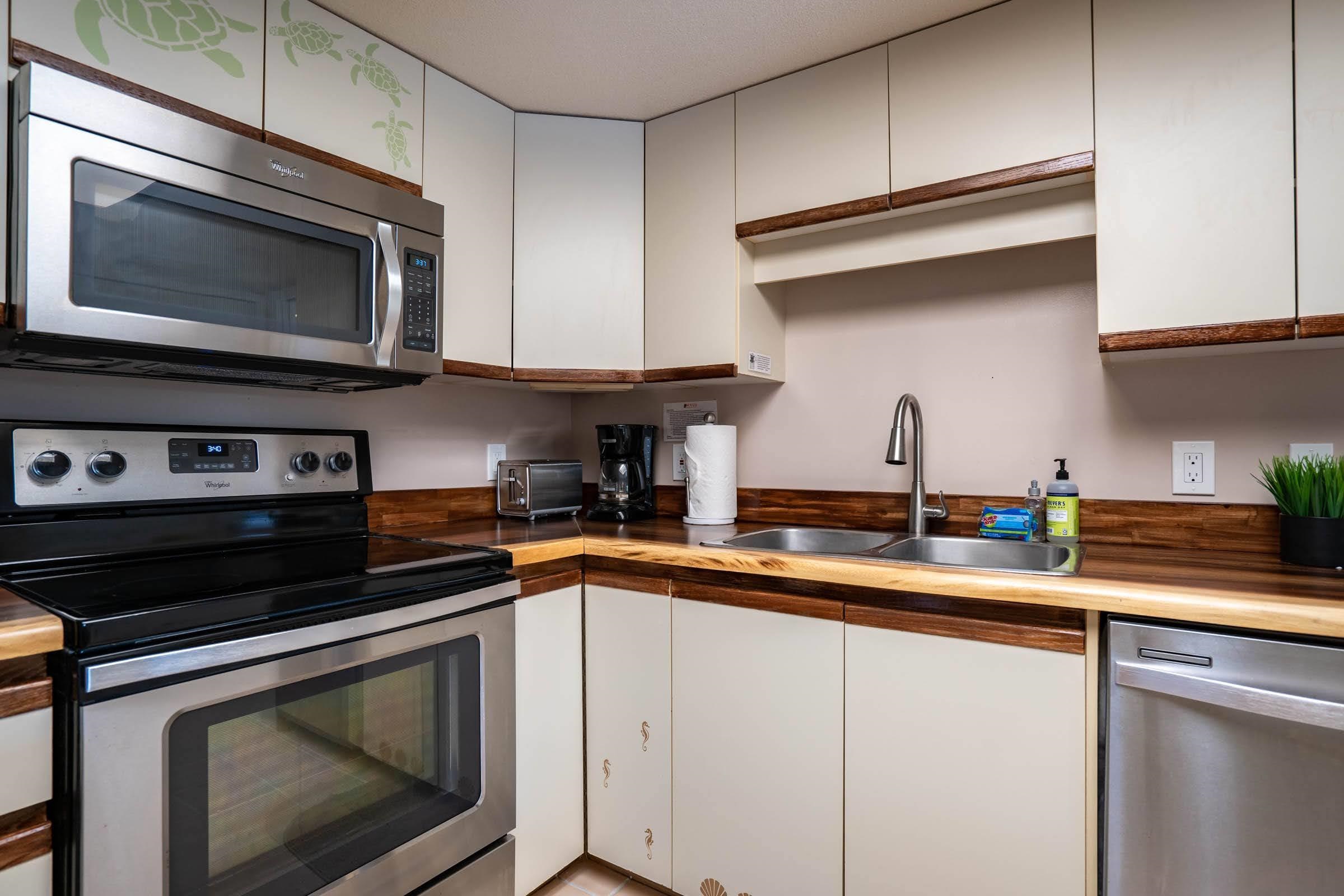 2575 South Kihei Road, Unit G209 Kihei, HI 96753 - Photo 6 of 27 a kitchen with stainless steel appliances a stove microwave and sink