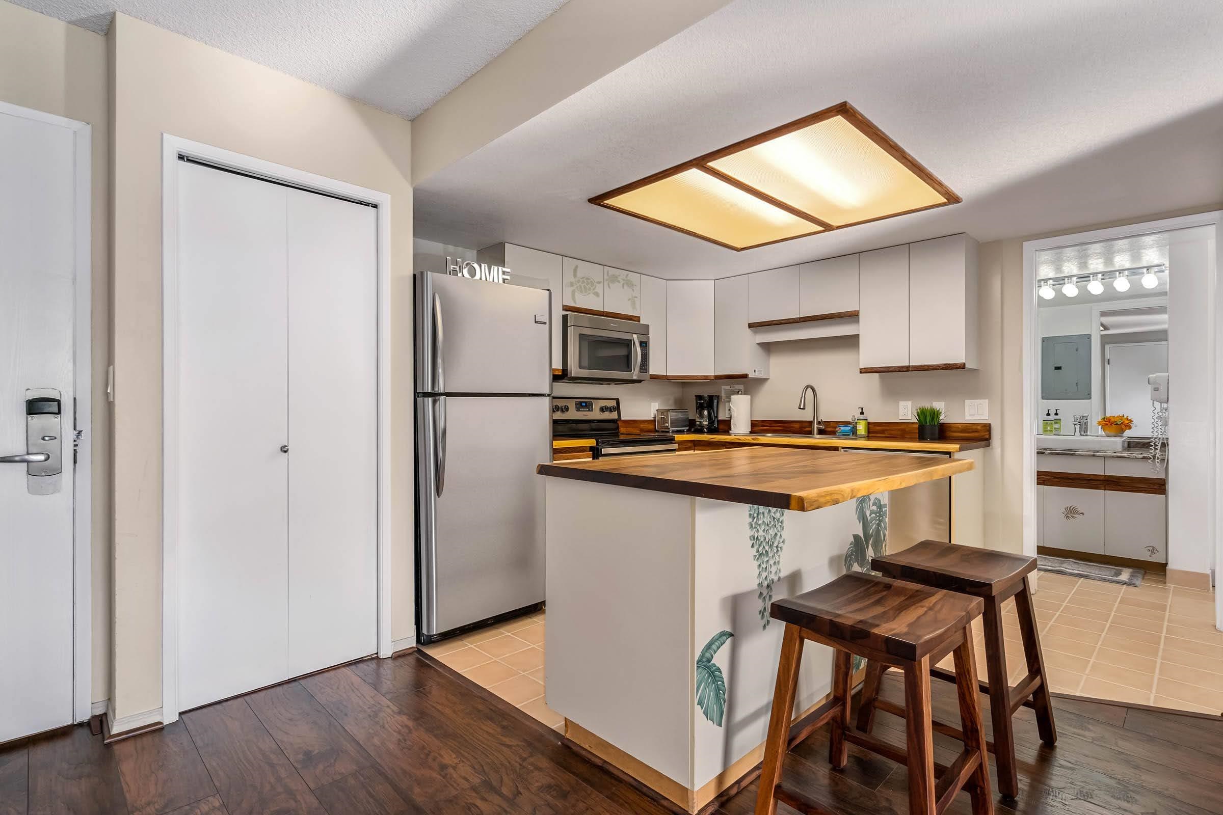 2575 South Kihei Road, Unit G209 Kihei, HI 96753 - Photo 10 of 27 a kitchen with a refrigerator a stove a sink and a microwave