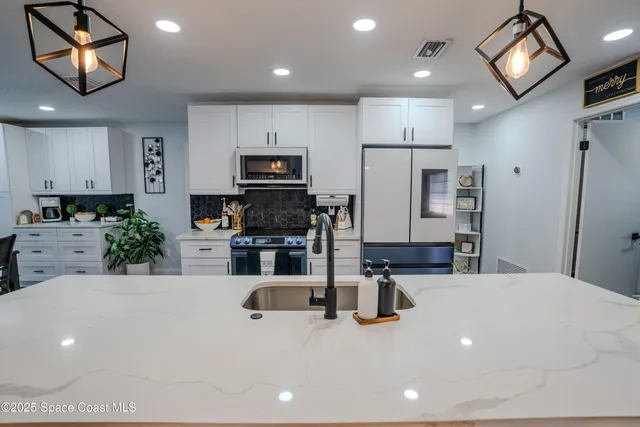 a kitchen with stainless steel appliances a refrigerator sink microwave and stove