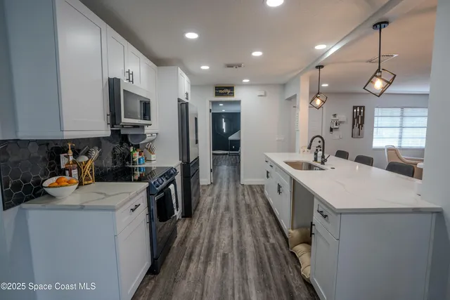 a kitchen with a sink a counter top space stainless steel appliances and a window
