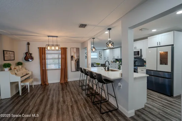 a kitchen with stainless steel appliances kitchen island granite countertop a refrigerator and a stove top oven