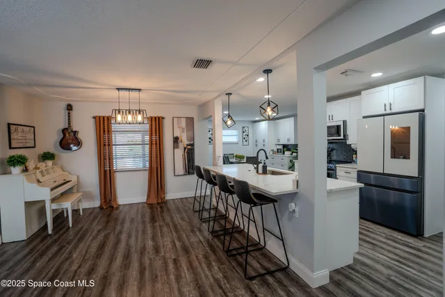 a kitchen with stainless steel appliances kitchen island granite countertop a refrigerator and a stove top oven