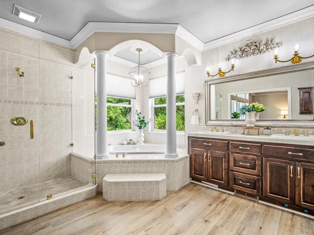a large bathroom with a tub sink and mirror