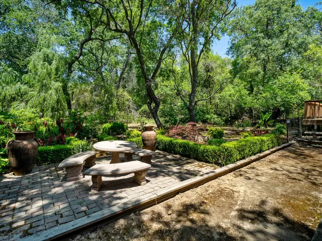 a wooden bench sitting in the middle of a garden