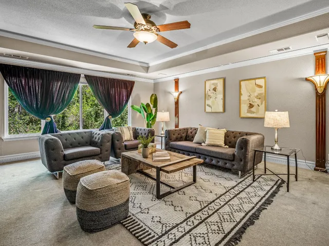 a living room with furniture a rug and a large window