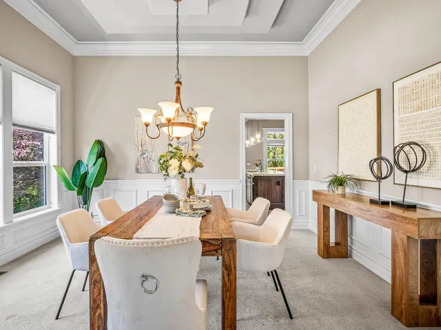 a dining room filled chandelier and kitchen view