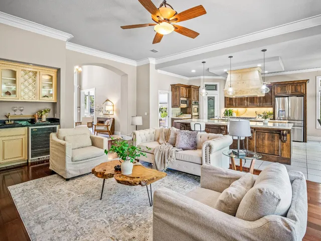 a living room with furniture kitchen view and a large window
