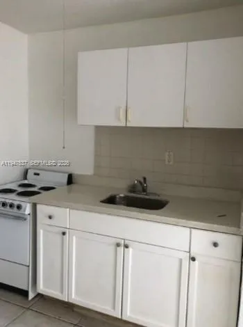 a kitchen with white cabinets and white appliances