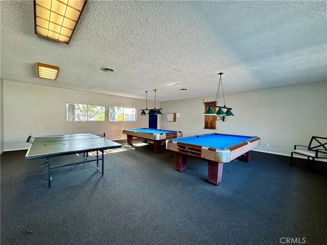 a living room with furniture pool table and windows