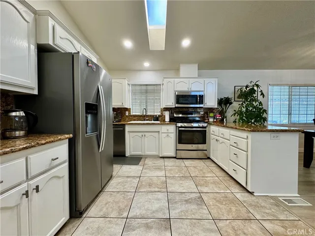 a kitchen with granite countertop a refrigerator and a sink