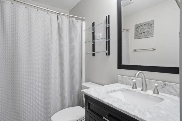 a bathroom with a granite countertop sink and a mirror